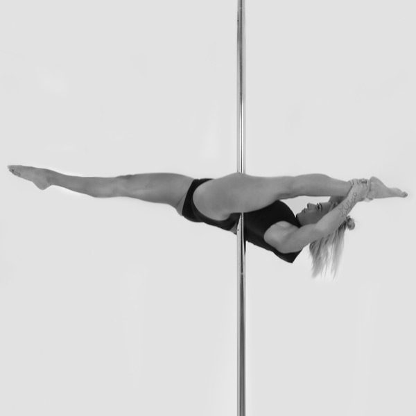 One woman holding a jade pose during a pole fitness class at The Pole Hub