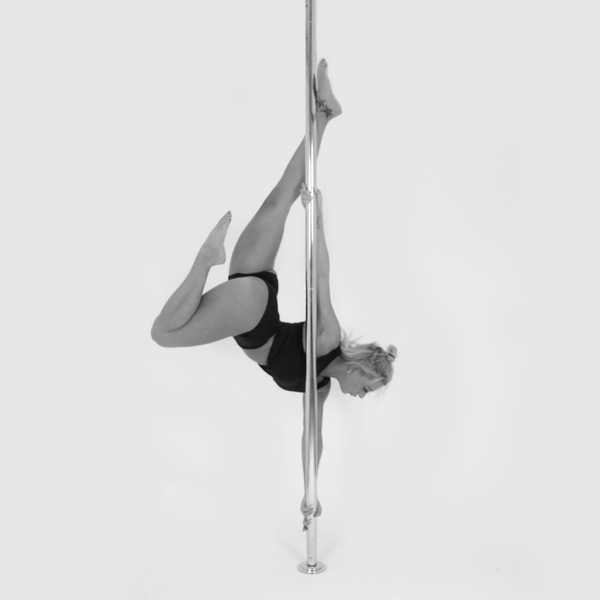 One woman holding an poisson pose during a pole fitness class at The Pole Hub