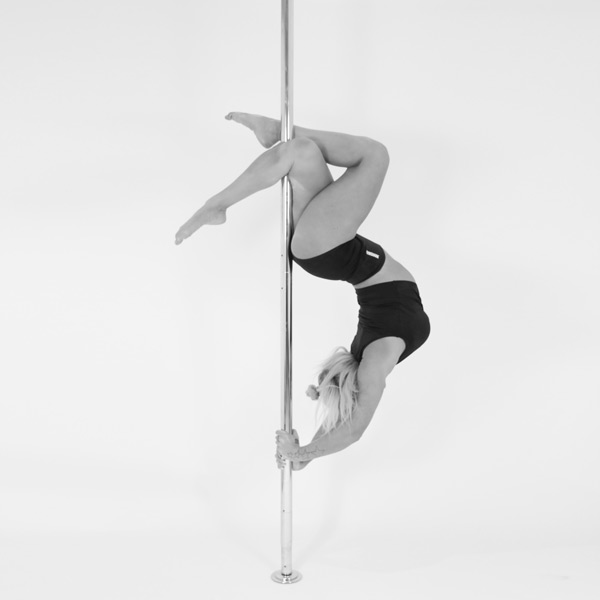 One woman holding a Russian layback pose during a pole fitness class at The Pole Hub