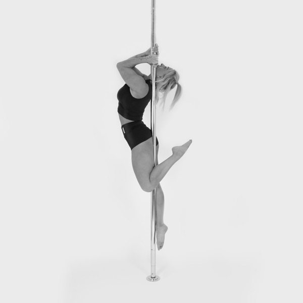 One woman holding a figurehead pose during a pole fitness class at The Pole Hub