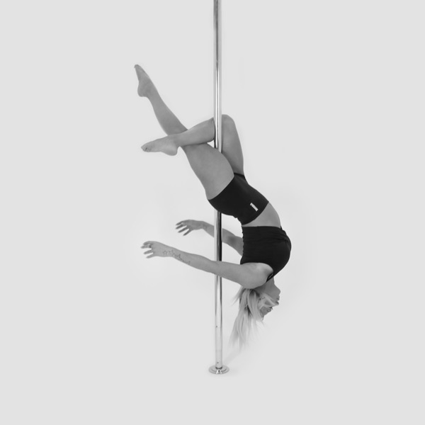 One woman holding a layback pose during a pole fitness class at The Pole Hub