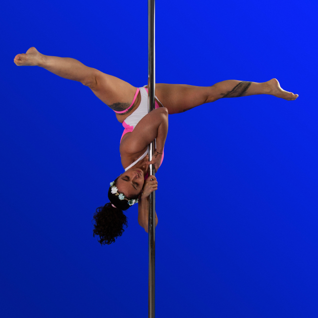 Instructor Carina D holding a pose during a pole fitness class at The Pole Hub