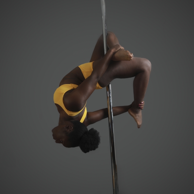 Instructor Chaniqua B-B holding a pose during a pole fitness class at The Pole Hub