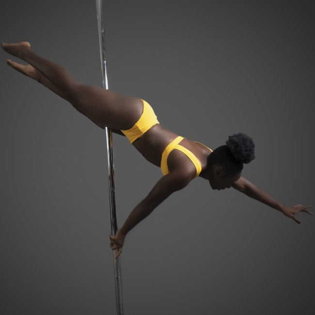 Instructor Chaniqua B-B holding a pose during a pole fitness class at The Pole Hub
