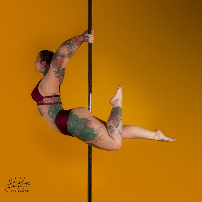 Instructor Fran S holding a Bridge Handstand pose during a pole fitness class at The Pole Hub