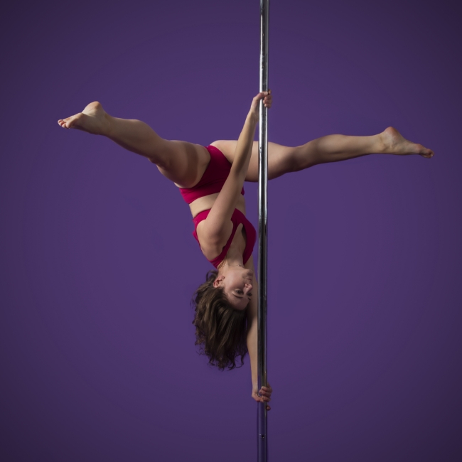 Instructor Kelly K holding a pose during a pole fitness class at The Pole Hub